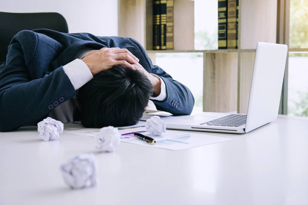 Feeling stress and headache, Businessman depressed and exhausted at his desk frustrated with problems with a pile of work while hiding his face on table. - Foto, Bild