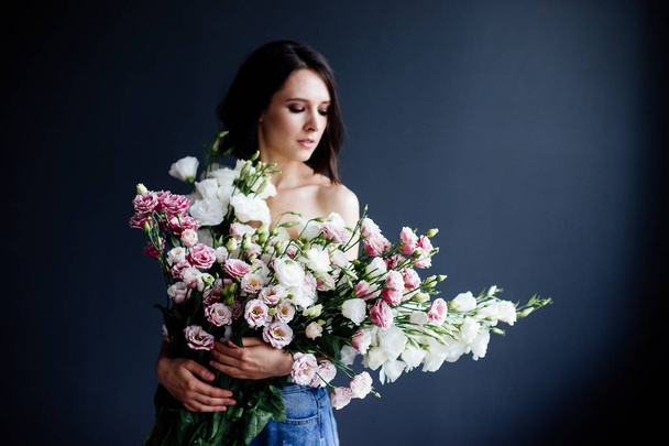 Beautiful girl with a bouquet flowers. - Foto, afbeelding