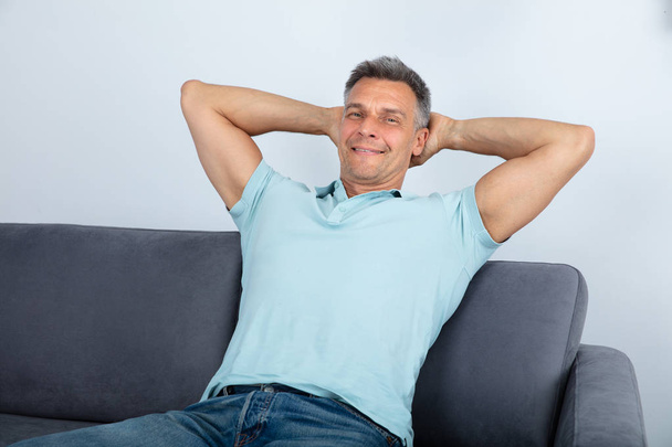 Relaxed Mature Man Sitting On Sofa At Home - Фото, зображення