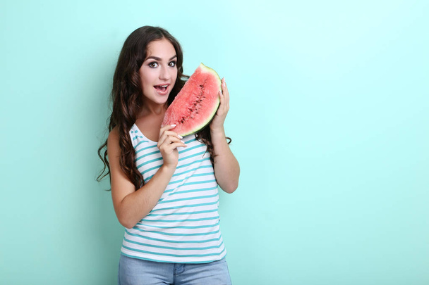 Beautiful woman with watermelon on mint background - 写真・画像