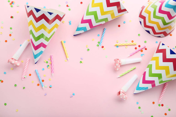 Birthday paper caps with candles and blowers on pink background - 写真・画像