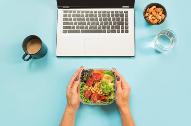 Healthy business lunch in the office, salad for snack, glass of water, almonds, cup of coffee on blue table. Top view with copy space. Concept proper nutrition. Lunchbox. Take away. - Fotoğraf, Görsel