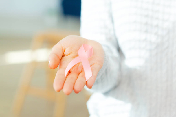female hands holding AIDS awareness ribbon - Fotografie, Obrázek