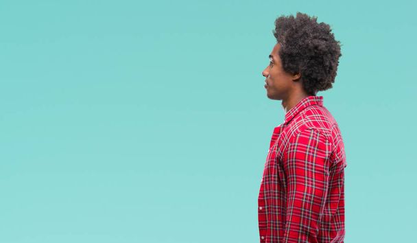 Afro american man over isolated background looking to side, relax profile pose with natural face with confident smile. - 写真・画像