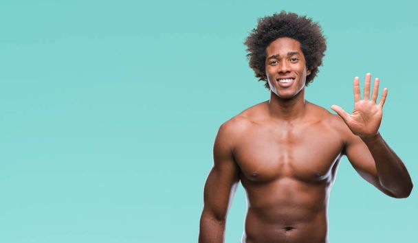 Afro Amerikaanse shirtless man naakt lichaam tonen over geïsoleerde achtergrond weergeven en met de vingers omhoog nummer vijf terwijl lacht zelfverzekerd en blij. - Foto, afbeelding