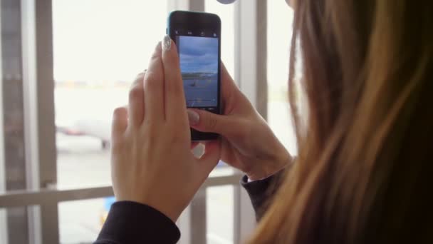 Smartphone video a repülőgép felszállás. Nő használata mobil videó repülőtéren - Felvétel, videó