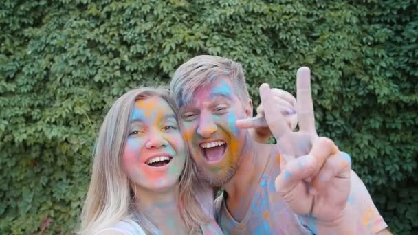 Jonge gelukkige paar plezier spelen met kleurrijke holi poeder - Video