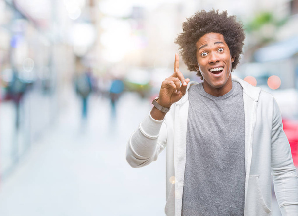 Afro american man wearing sweatshirt over isolated background pointing finger up with successful idea. Exited and happy. Number one. - Foto, immagini
