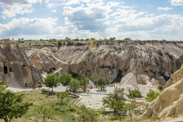 Люди исследуют камины сказок в Каппадокии с голубым небом на заднем плане в Гореме, Невшехир, Турции.15 Июнь 2014
 - Фото, изображение