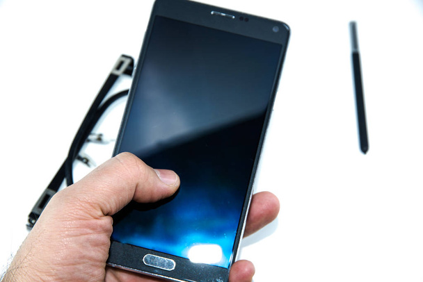 man vinger touch op grote slimme telefoon met slimme pen-pen in handen geïsoleerd op de witte achtergrond en met bril - Foto, afbeelding