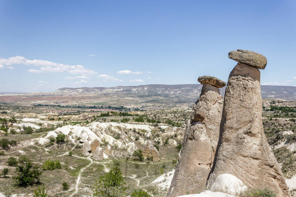 Fairy tale chimneys in Cappadocia with blue sky on background in Goreme,Nevsehir, Turkey - Photo, image