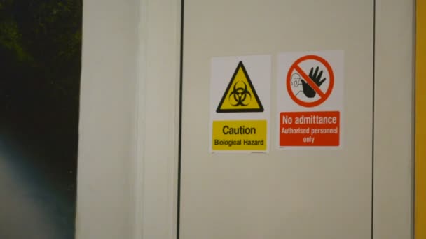 Zoom in on Caution Biological Hazard and No Admittance warning danger signs on the door - Footage, Video
