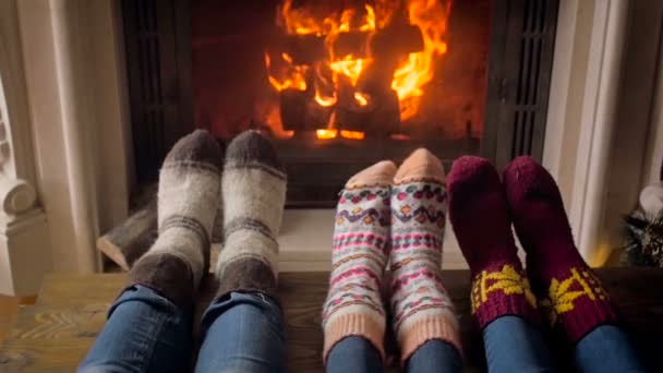 Slow motion video młode rodziny sobie skarpetki ocieplenia przy kominku w salonie - Materiał filmowy, wideo