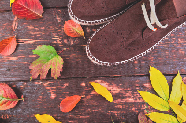 Brown man suede boots espadrilles  on wooden background with leaves. Autumn or winter shoes.  Flat lay.  - Foto, Imagen
