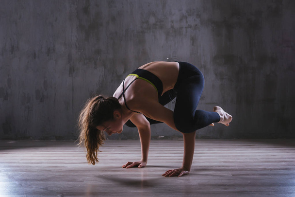 Fitness woman training in dark studio. Young girl posing on black background - Foto, immagini