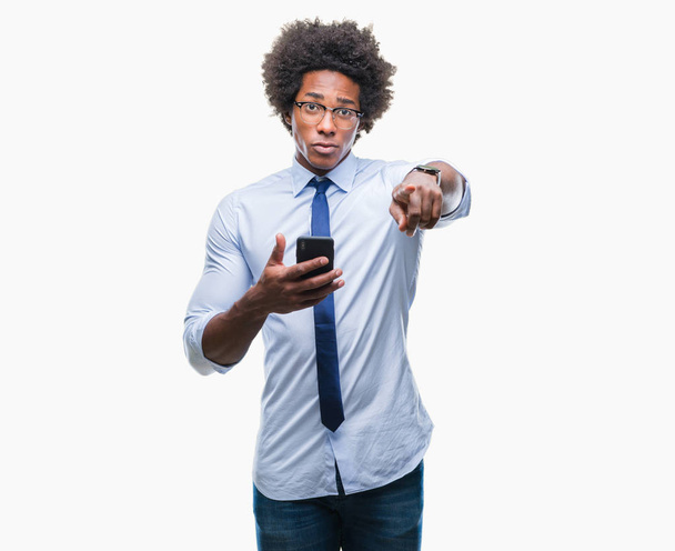 Afro américain homme d'affaires textos à l'aide d'un smartphone sur fond isolé pointant du doigt vers la caméra et à vous, signe de la main, geste positif et confiant de l'avant
 - Photo, image