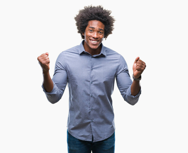 Afro-Amerikaanse man over geïsoleerde achtergrond vieren verrast en verbaasd voor succes met armen aan de orde gesteld en ogen open. Winnaar concept. - Foto, afbeelding
