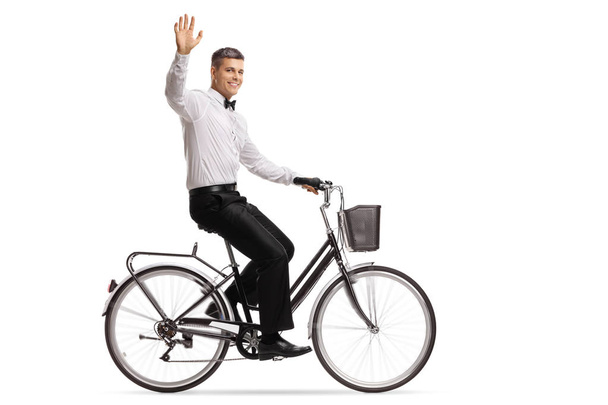 Groom riding a bicycle and waving at the camera isolated on white background - Photo, Image