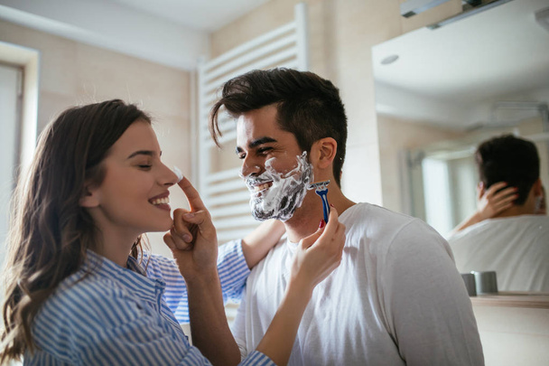 Young woman shaving a man's beard - Foto, Imagem