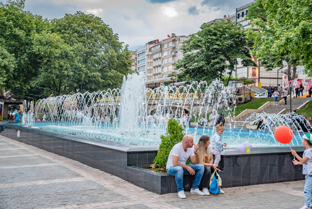 Persone non identificate passeggiano intorno alla piscina in Piazza Orhangazi nel centro di Bursa.Bursa, Turchia.
 - Foto, immagini