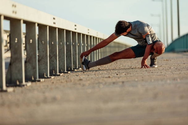 Man stretching before his run - Foto, afbeelding