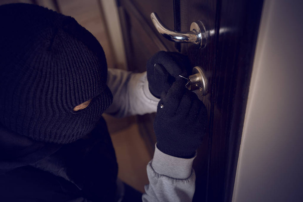 burglar breaking into the lock on the front door - Foto, afbeelding