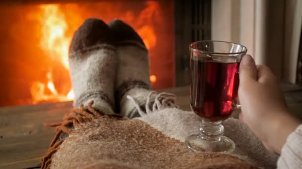 Zeitlupenaufnahmen einer Frau in warmen Wollsocken, die Tee am Kamin trinkt - Filmmaterial, Video