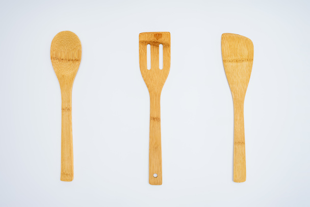 top view of arranged wooden kitchen utensils isolated on grey - Foto, immagini