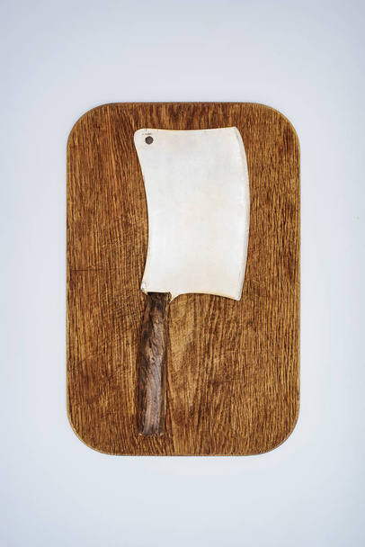 vista superior del cuchillo de carne sobre tabla de cortar de madera aislada en gris
  - Foto, imagen