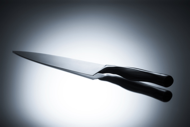 vista ravvicinata del singolo coltello da cucina riflesso sul grigio
 - Foto, immagini