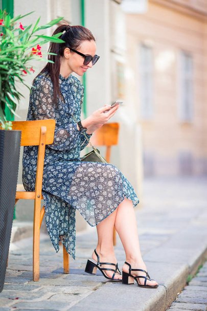Nainen puhuu älypuhelimellaan kaupungissa. Nuori houkutteleva turisti ulkona Italian kaupunki
 - Valokuva, kuva