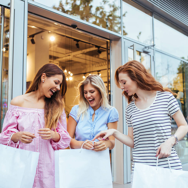 Three young women with shopping bags - Foto, imagen