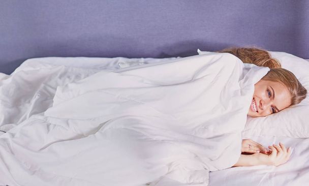 Beautiful girl sleeps in the bedroom, lying on bed - Valokuva, kuva