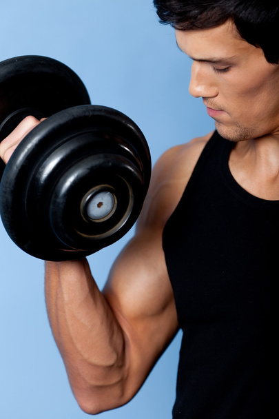 Handsome muscular man with dumbbell, close up - Photo, Image