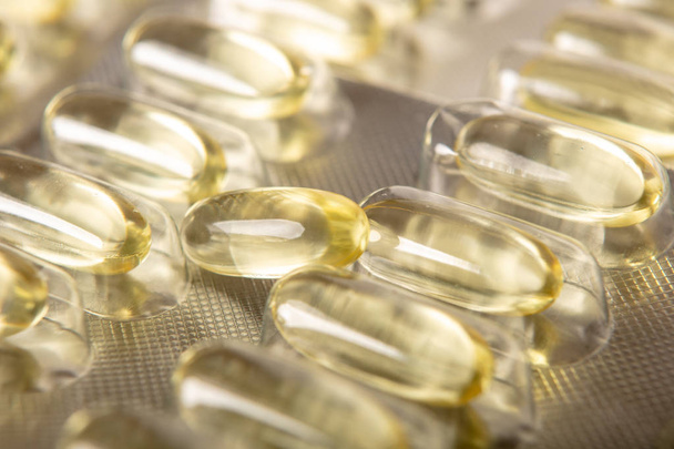 Yellow color vitamin pills with omega 3 , epa and dha . Fish oil capsule pils close up background - Fotografie, Obrázek