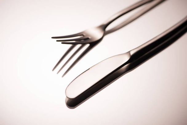 close-up view of shiny fork and knife reflected on grey - Фото, зображення