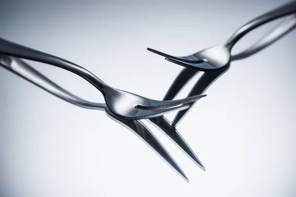 close-up view of shiny forks with two tines reflected on grey  - Photo, Image