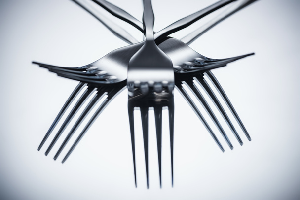 close-up view of shiny stainless steel forks reflected on grey    - Φωτογραφία, εικόνα