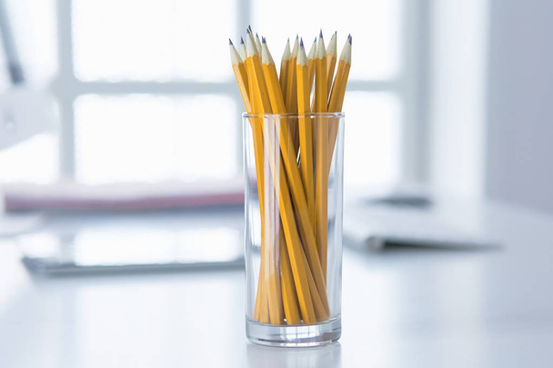 Grafit ceruza, egy üveg csésze az irodai asztal. Koncepció - Fotó, kép