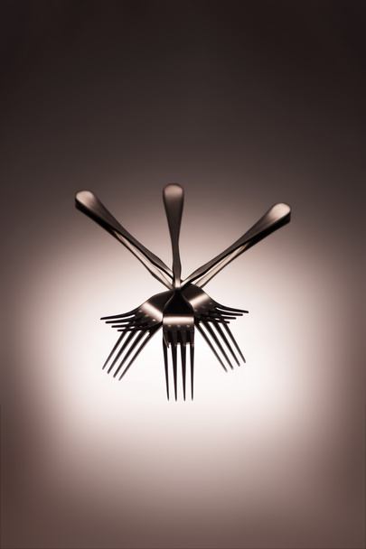 Detailní pohled lesklé kovové vidličky na šedá    - Fotografie, Obrázek