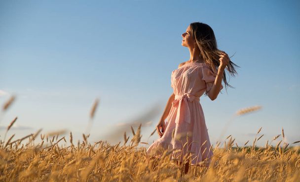 Young woman in wheat field at sunset - Foto, Imagem