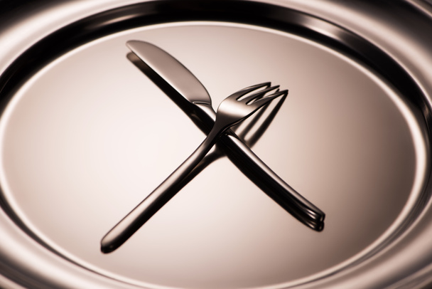 close-up view of shiny fork and knife arranged on metal tray  - 写真・画像