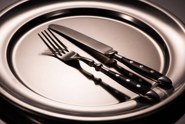 vista de cerca de tenedor y cuchillo en bandeja de metal brillante en gris
 - Foto, Imagen