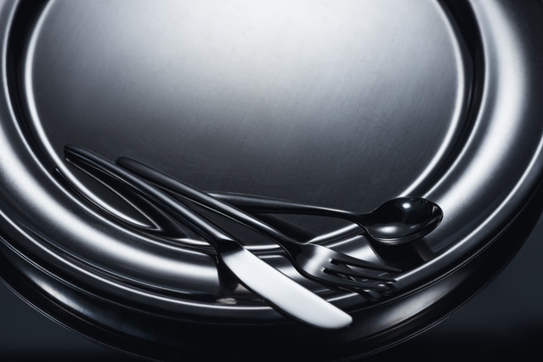 close-up view of cutlery on shiny metal tray on grey  - Foto, Imagen