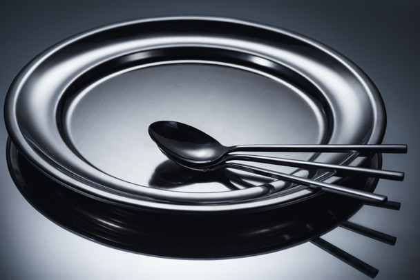three spoons arranged on shiny metal tray on grey  - Photo, Image