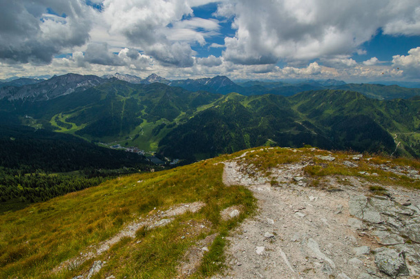 verde paisaje montañoso con cielo azul nublado visto desde la cima de la colina
 - Foto, imagen