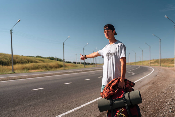 Travel man hitchhiking. Backpacker on road - Photo, image