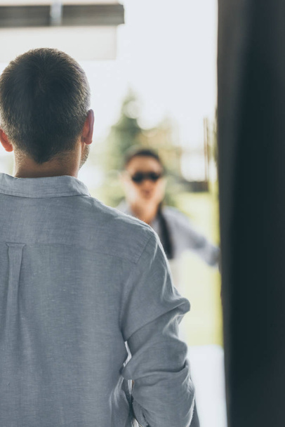 rear view of man walking to girlfriend waiting him at home  - Фото, изображение