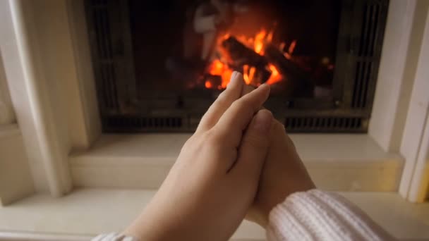 Detailní záběry mladé ženy oteplování ruce na hořící oheň na chladné zimní den - Záběry, video