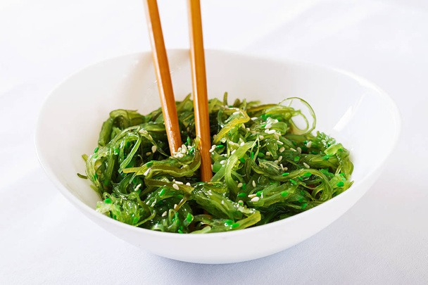 Wakame Chuka or seaweed salad  with sesame seeds in bowl on white background. Traditional Japanese food. - Photo, Image